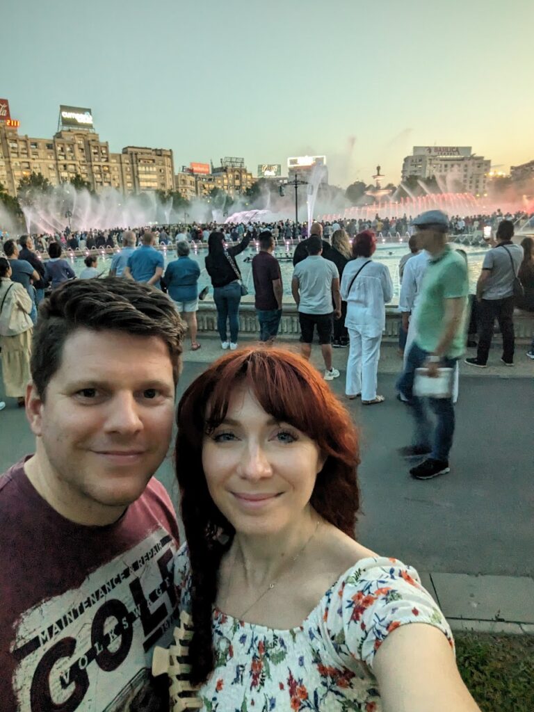 A man and woman stood outside a water fountain