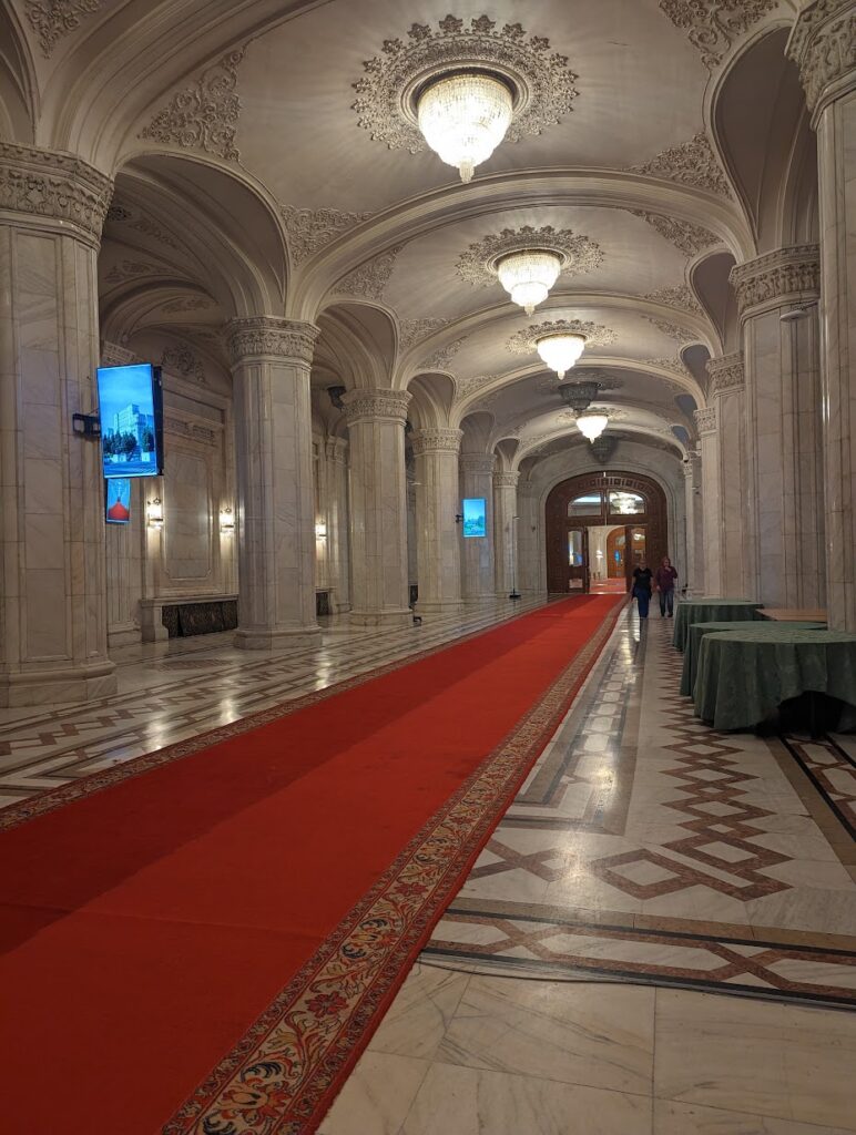 A marble interior of a building with a red carpet